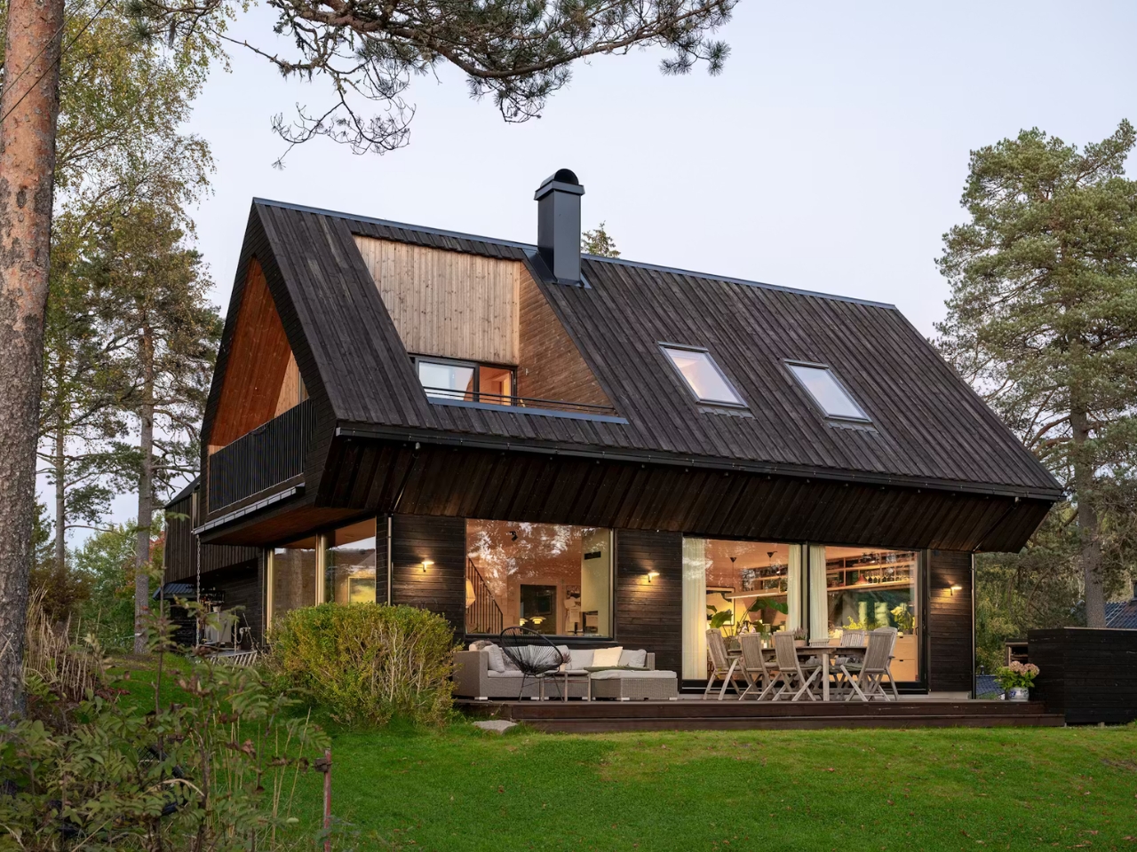 Cette maison en bois sombre se fond dans une forêt norvégienne