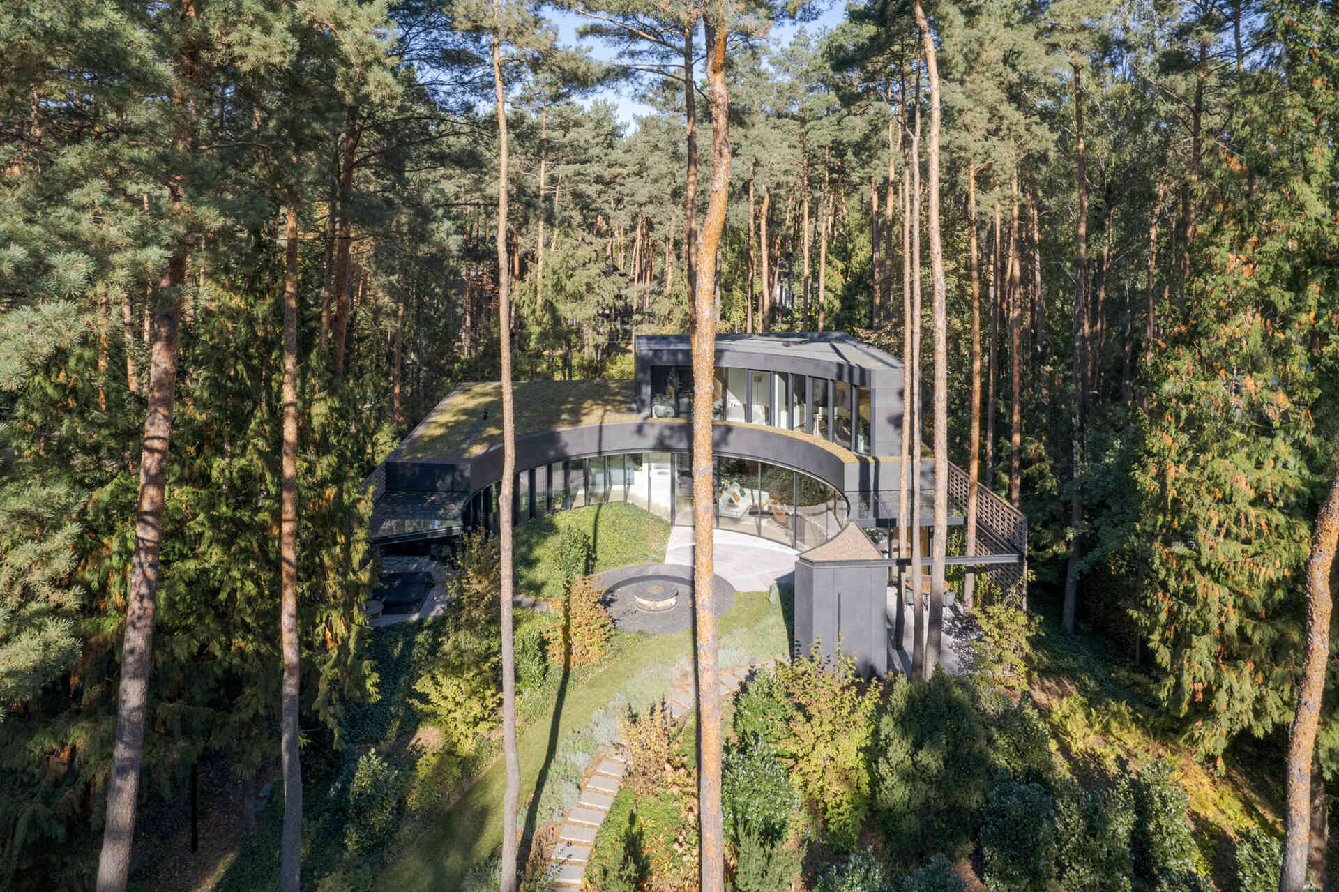 Le verre courbé et la brique définissent cette maison forestière